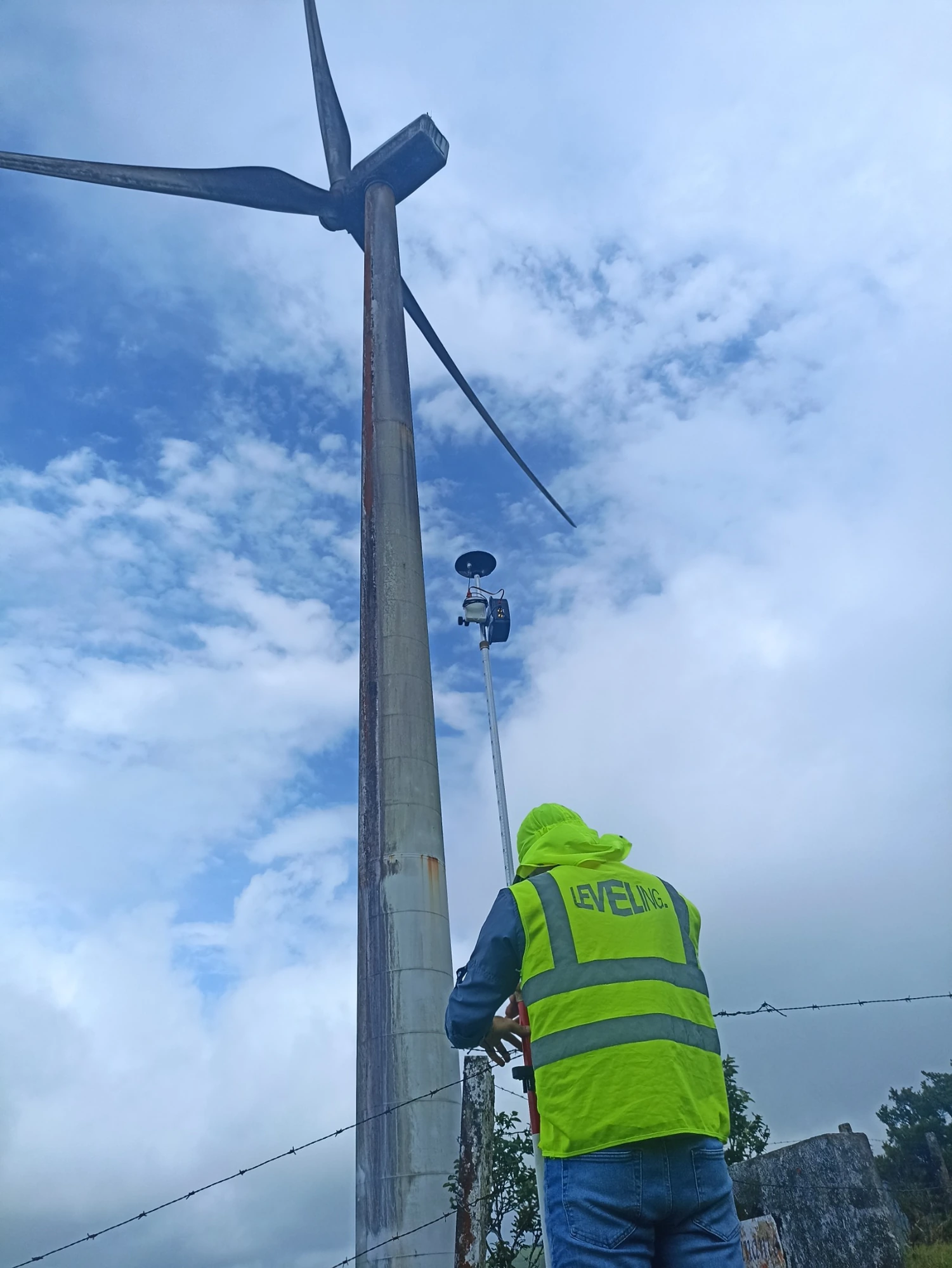 Field surveying beside a wind turbine